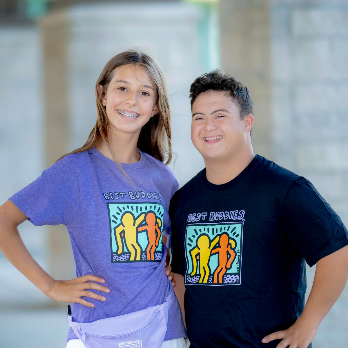 girl wearing purple haring tee standing next to a boy in the black haring tee