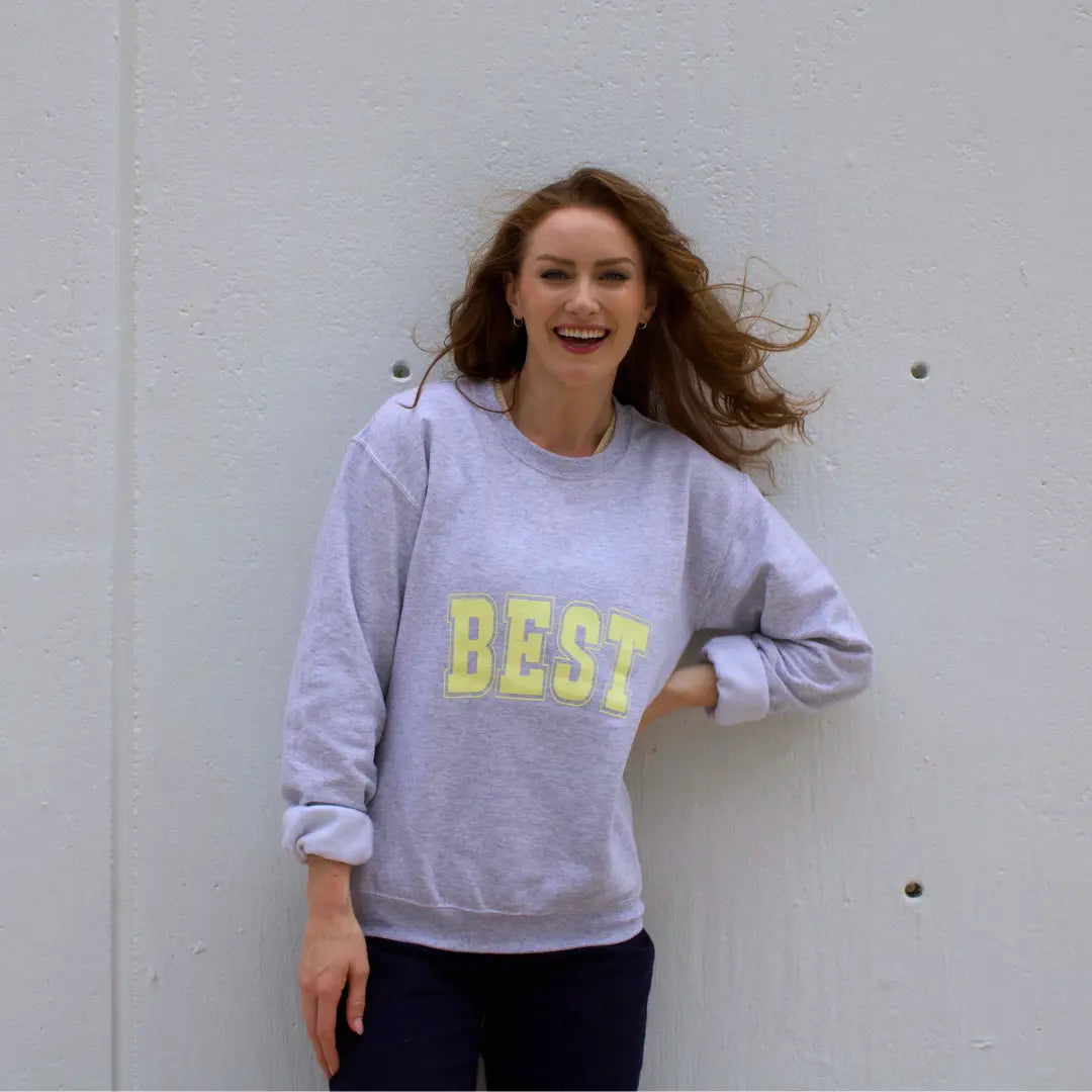 Grey crewneck sweatshirt with "Best" on the front and "Buddies" on the back in yellow lettering