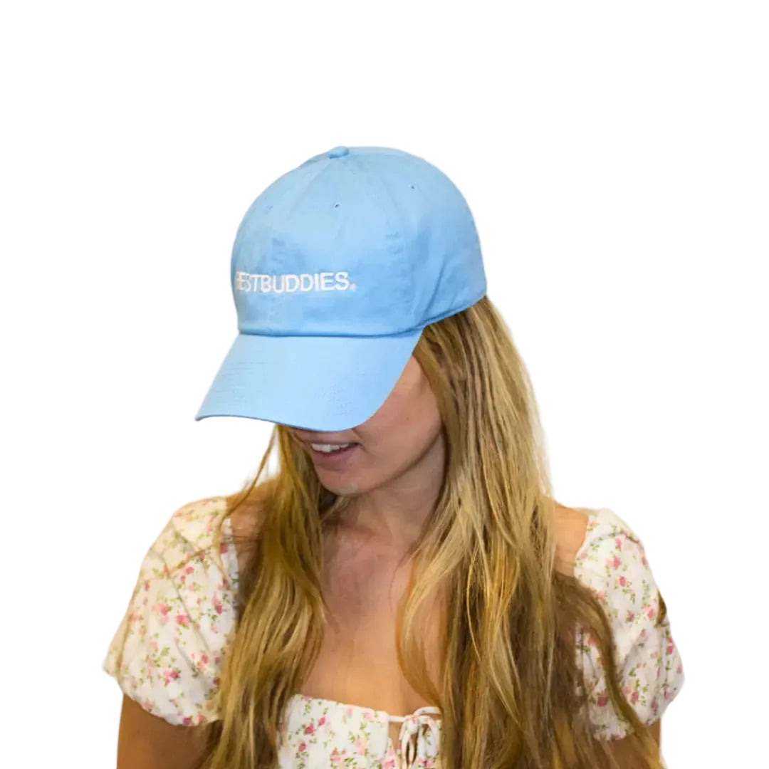 girl looking down wearing a carolina blue hat that says best buddies on front of hat