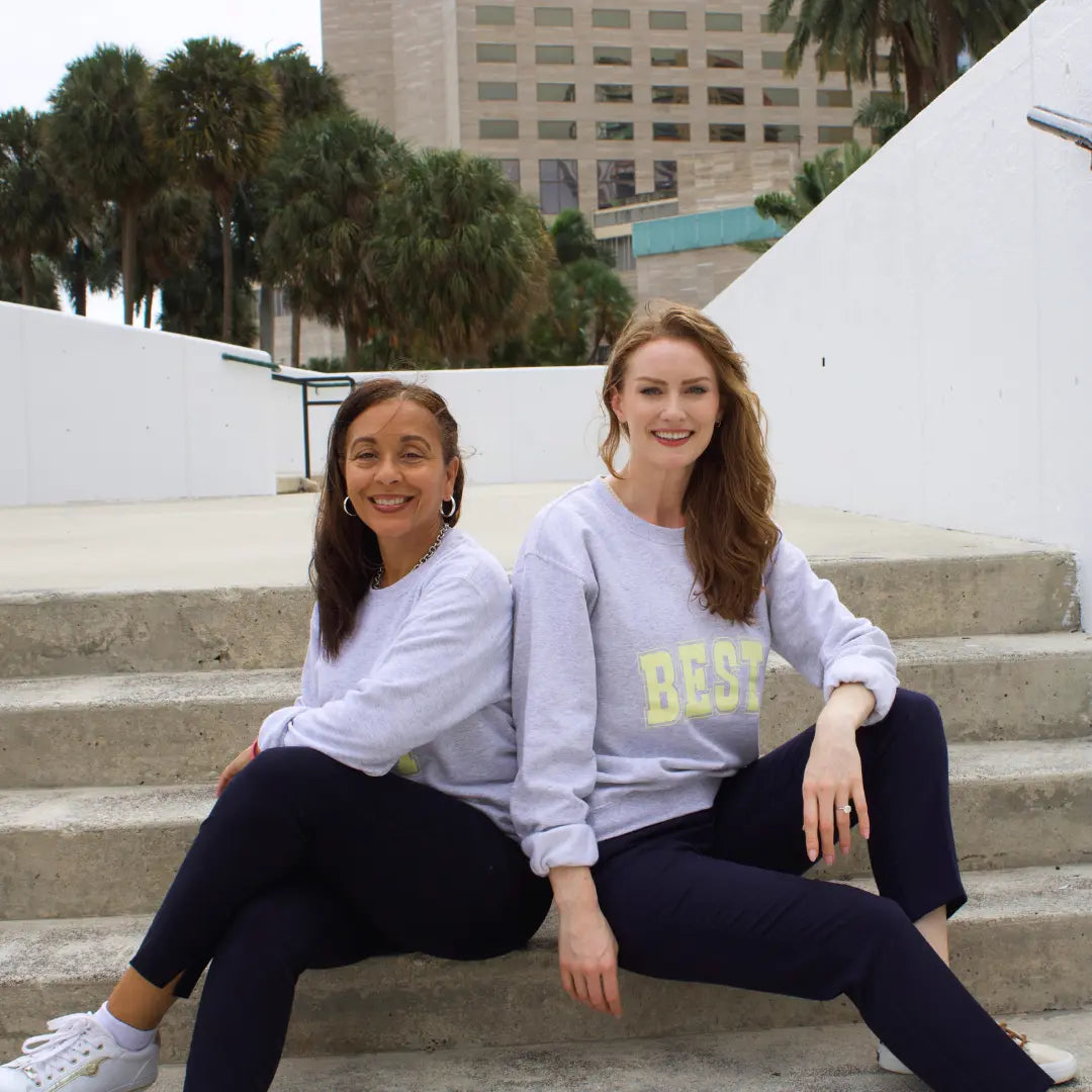 Grey crewneck sweatshirt with "Best" on the front and "Buddies" on the back in yellow lettering
