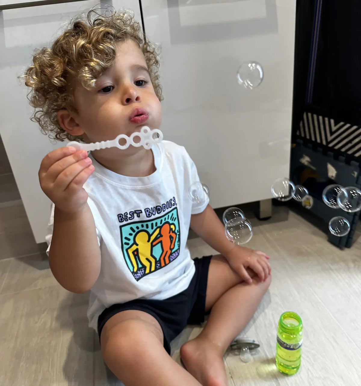 White toddler tee shirt with colorful traditional Haring Best Buddies Logo on the front