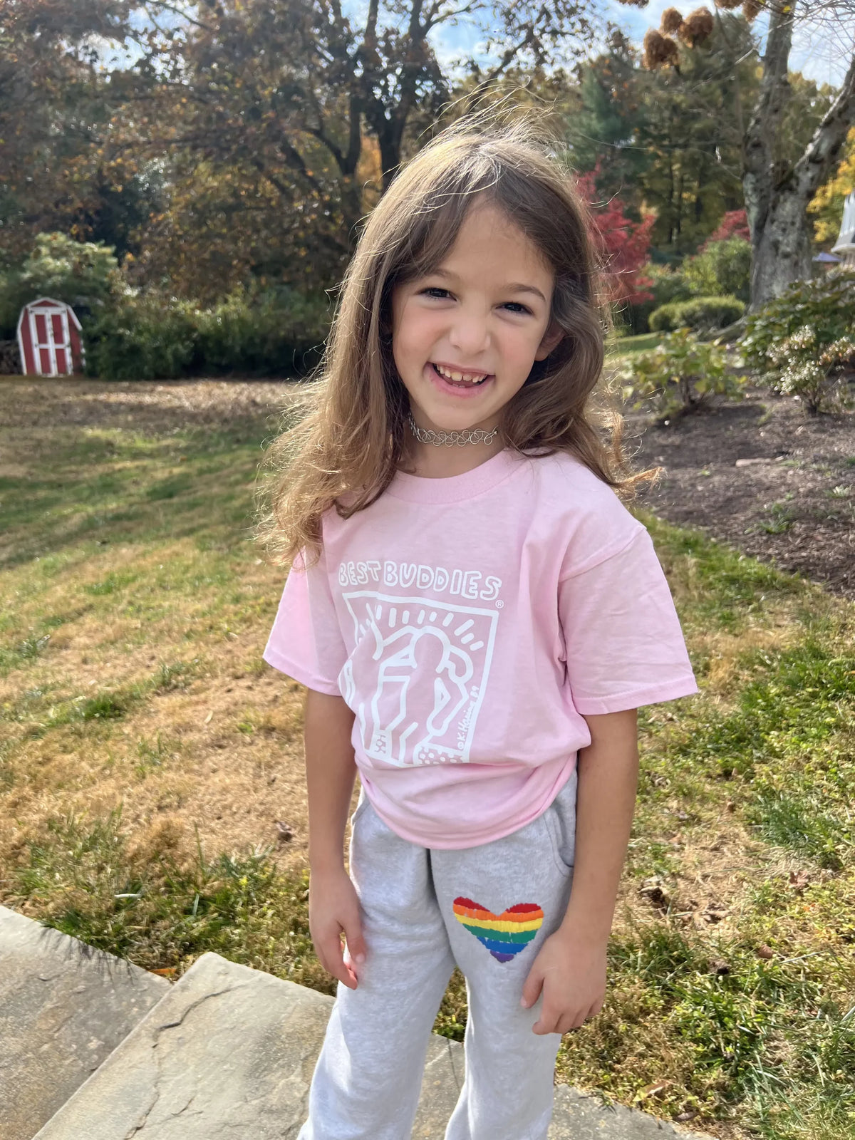 Pink youth shirt with White Haring Best Buddies Logo on the front
