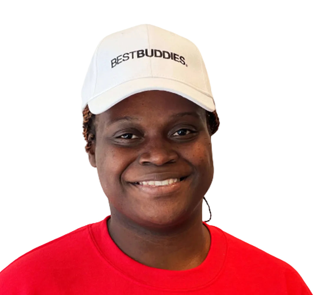 A Best Buddies Female Participant is seen smiling and wearing a Best Buddies white hat with a black Typeface logo.