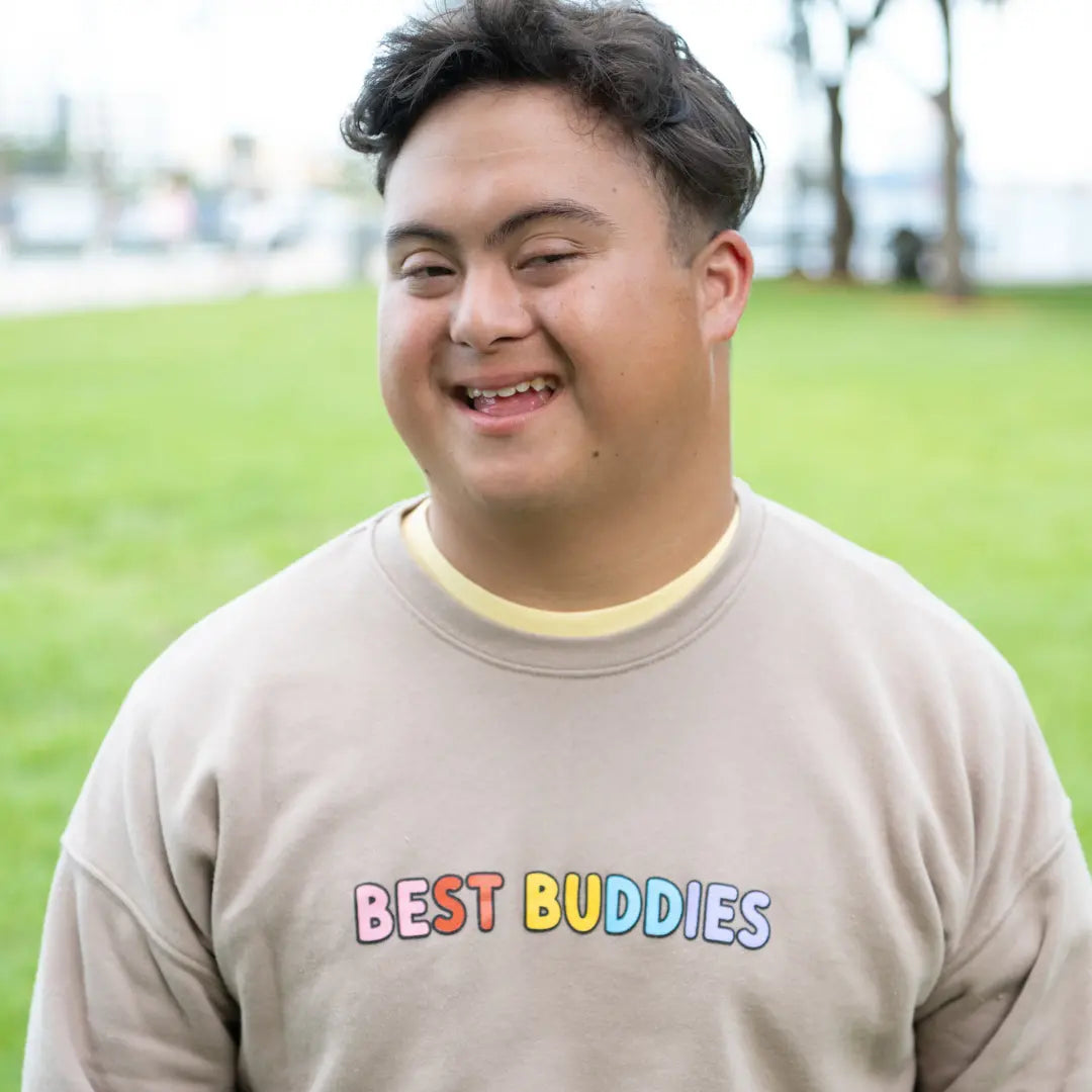 Best Buddies Crewneck beige Sweatshirt with ‘You Deserve to Be Included’ message printed in colorful letters on the back.