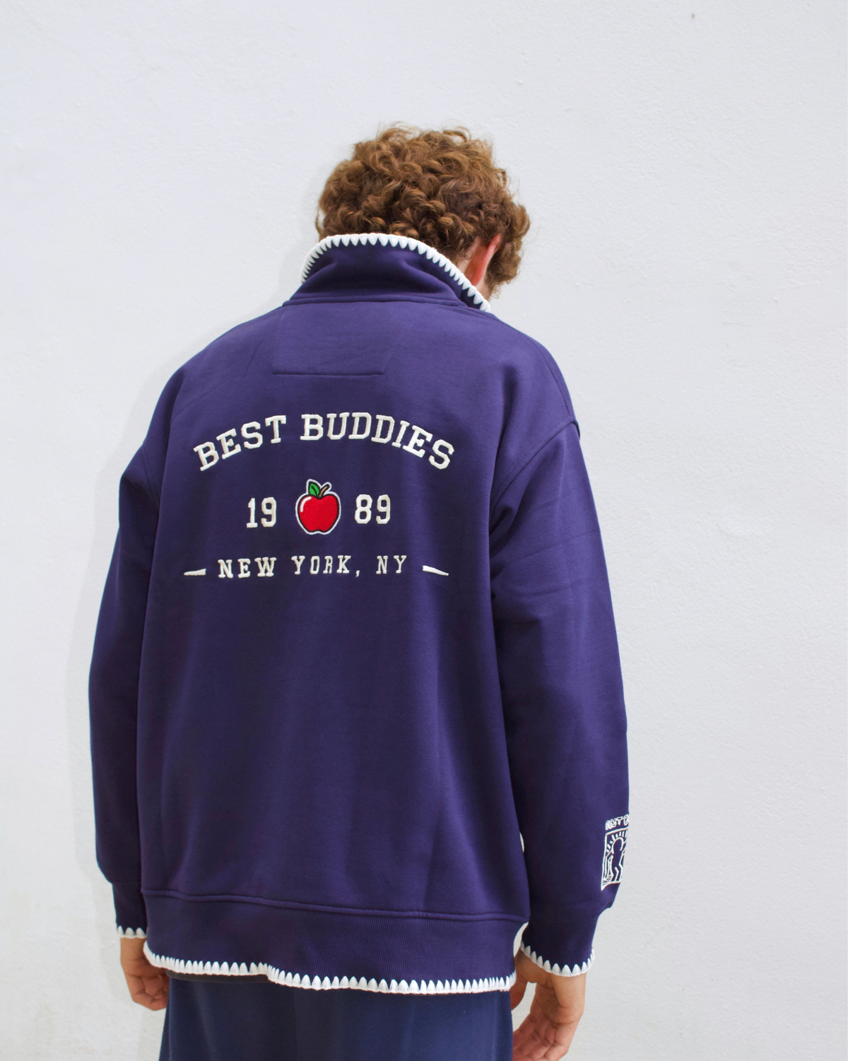 Model wearing a navy blue quarter-zip sweatshirt, back view.