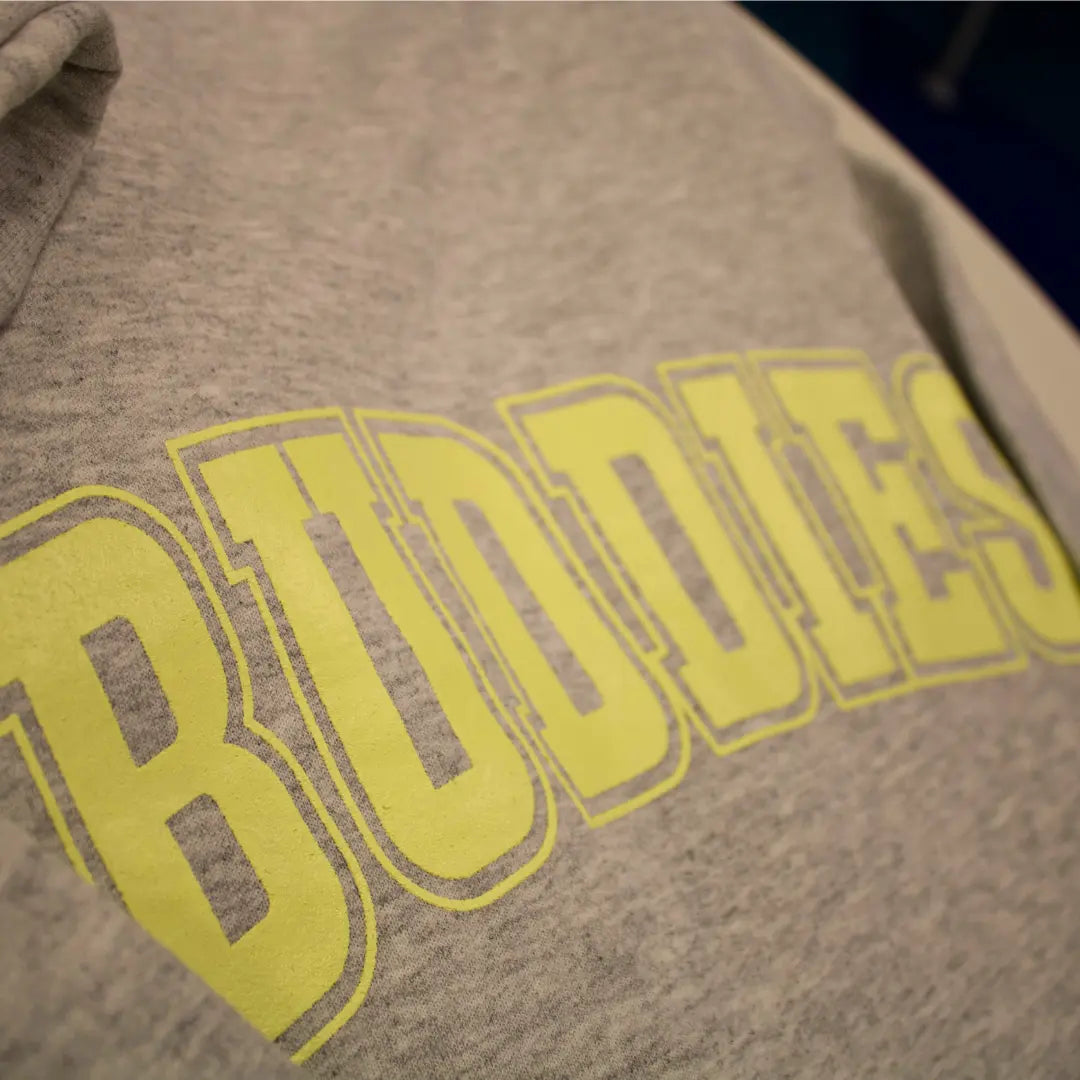Grey crewneck sweatshirt with "Best" on the front and "Buddies" on the back in yellow lettering